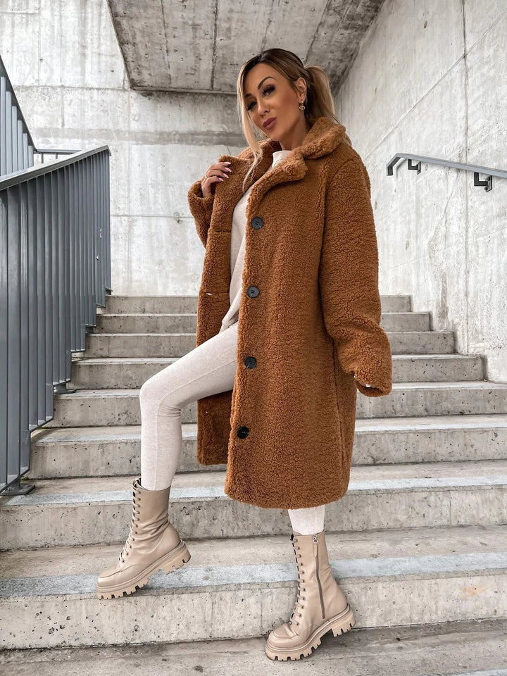 Frau in braunem Teddy-Mantel und beigen Stiefeln auf Treppe, modischer Winterlook, urbane Kulisse, stilvolle Damenbekleidung, Herbstmode 2023.