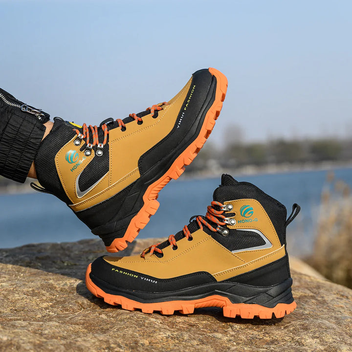Wasserdichte Wanderschuhe für Herren, gelb-schwarz, mit rutschfester Sohle und orangefarbenen Schnürsenkeln, ideal für Outdoor-Aktivitäten.