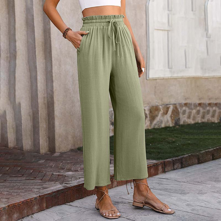 Damenhose in Olivgrün, locker geschnitten, mit elastischem Bund und Kordelzug, kombiniert mit Sandalen. Ideal für Sommermode und Freizeitoutfits.
