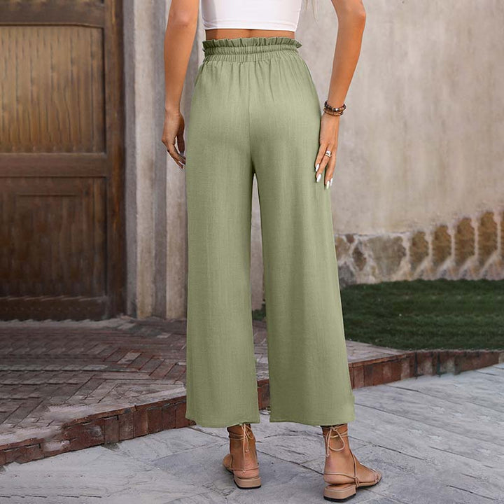 Grüne Damenhose mit weitem Bein, hoher Taille und elastischem Bund, getragen von einer Frau. Perfekt für Sommermode und lässige Outfits.