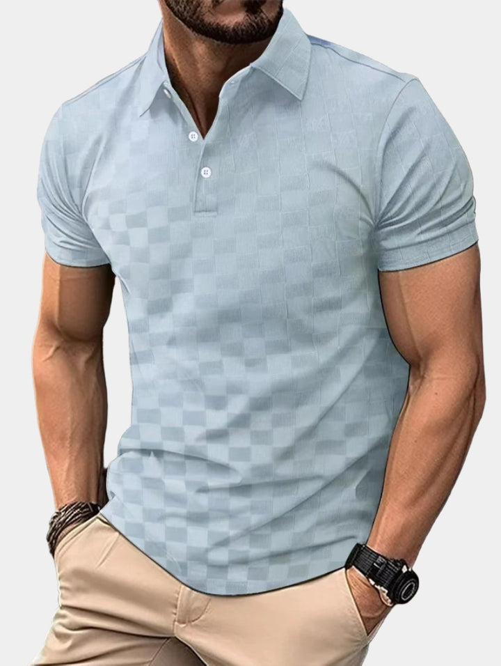 Mann trägt hellblaues kariertes Poloshirt, kombiniert mit beigen Hosen. Modischer Freizeitlook, ideal für Sommer und Freizeitaktivitäten.
