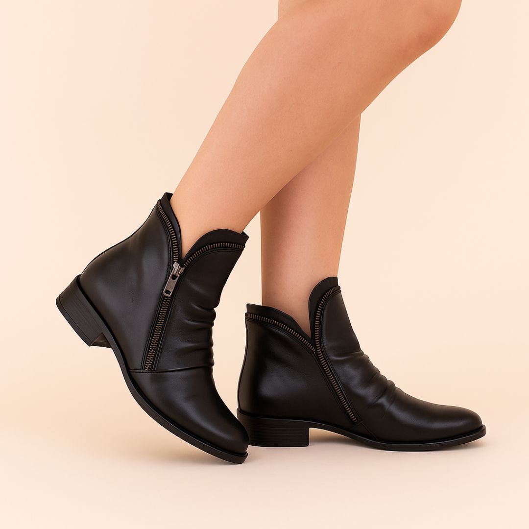 Schwarze Damenstiefeletten mit Reißverschluss, elegant und modern, auf beigem Hintergrund. Perfekt für Herbstmode und stilvolle Outfits.