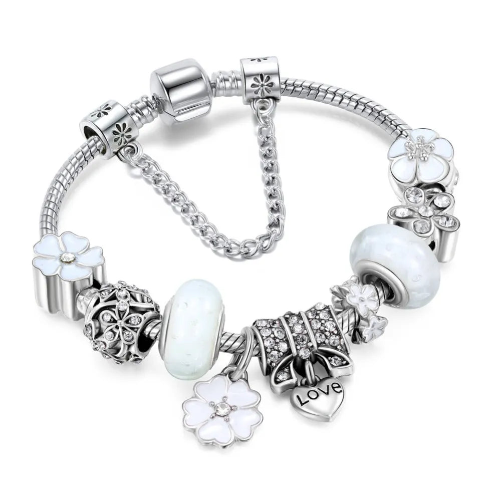 Silberarmband mit weißen Blumen- und Herzanhängern, verziert mit Kristallen. Elegantes Schmuckdesign, ideal für Damenmode und Geschenke.