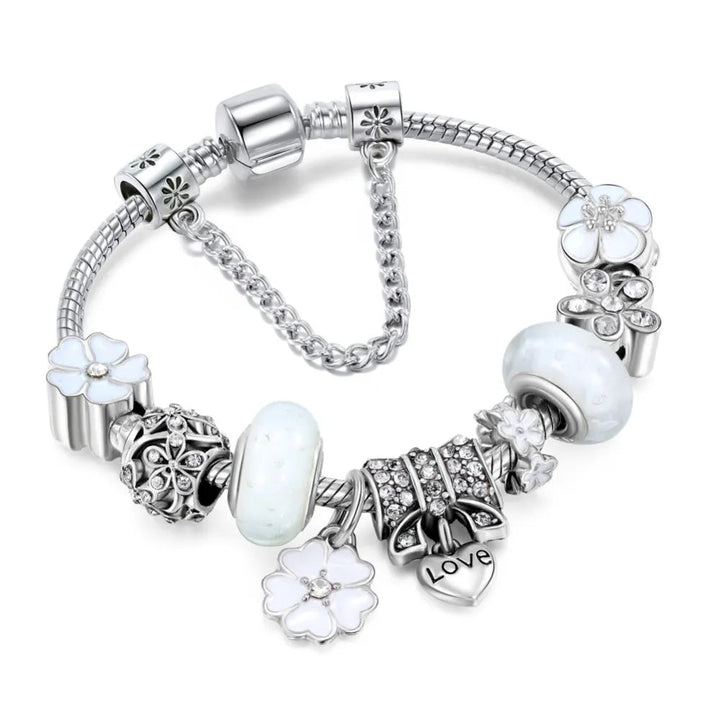 Silberarmband mit weißen Blumen- und Herzanhängern, verziert mit Kristallen. Elegantes Schmuckdesign, ideal für Damenmode und Geschenke.
