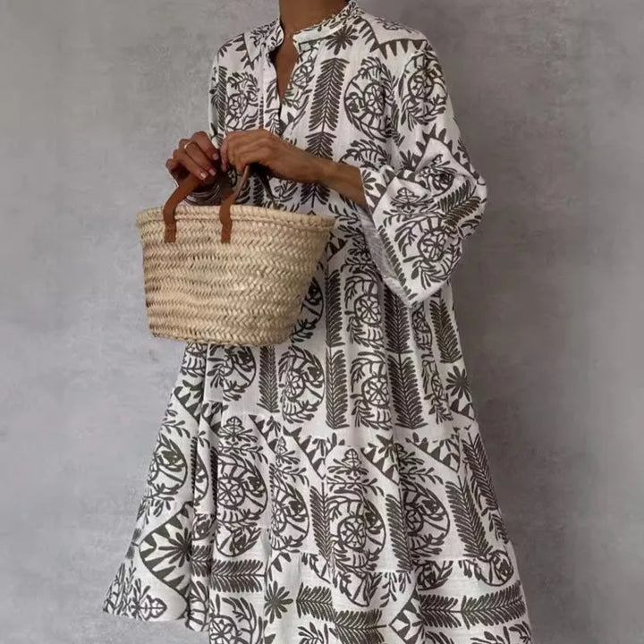 Dame in geblümtem Kleid hält geflochtene Strohtasche. Modetrend, Sommerkleid, Boho-Stil, Accessoire, elegantes Design, Freizeitlook.