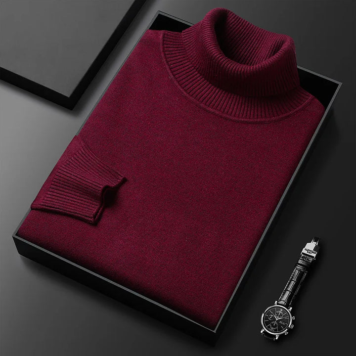 Bordeauxroter Rollkragenpullover in Geschenkbox, elegant gefaltet, neben einer stilvollen Armbanduhr auf schwarzem Hintergrund.