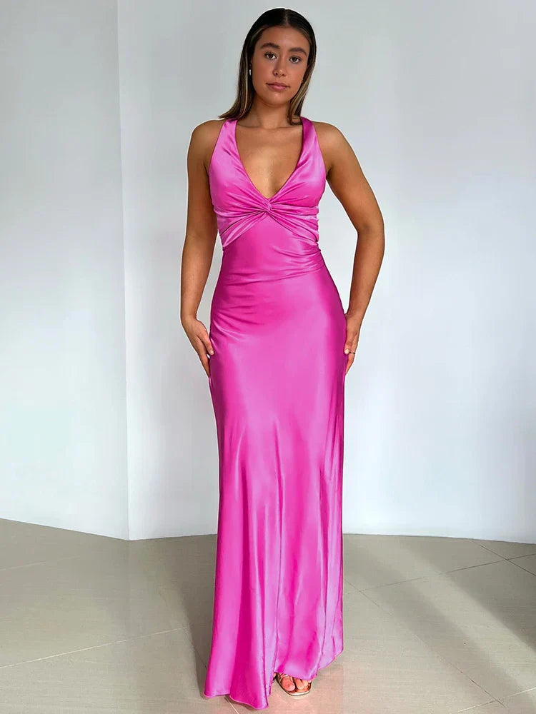 Frau in elegantem, pinkem Abendkleid mit tiefem Ausschnitt, stehend vor weißem Hintergrund. Perfekt für Mode, Abendmode, Damenkleider.