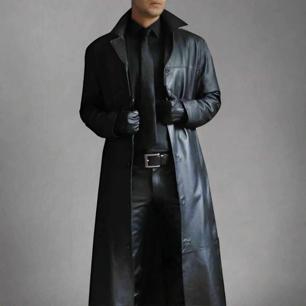 Mann in schwarzem Ledermantel, Lederhandschuhen und Krawatte. Stilvolle Herrenmode, eleganter Look, zeitloser Ledermantel, modisches Outfit.