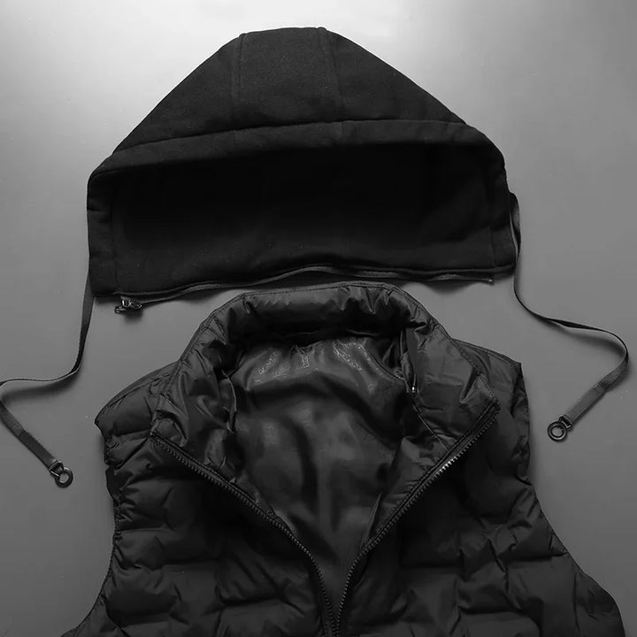 Schwarze, abnehmbare Kapuze und gesteppte Weste auf grauem Hintergrund. Modische, warme Winterbekleidung, vielseitig kombinierbar.