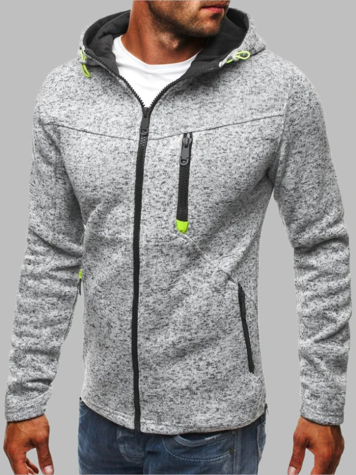 Grauer Herren-Kapuzenpullover mit Reißverschluss, schwarzen Akzenten und grünen Details. Modischer Freizeitlook, ideal für Herbst und Winter.