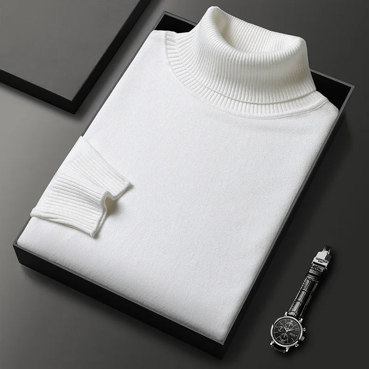 Weiße Rollkragenpullover in Geschenkbox neben schwarzer Armbanduhr auf grauem Hintergrund. Elegante Herrenmode, stilvolles Accessoire.