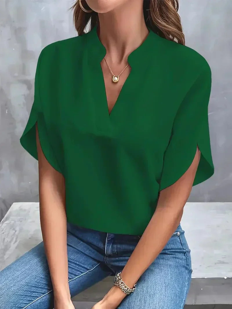 Grüne Bluse Damen, lässig elegant, V-Ausschnitt, kurze Ärmel, kombiniert mit blauer Jeans, modisches Outfit, ideal für Freizeit und Büro.