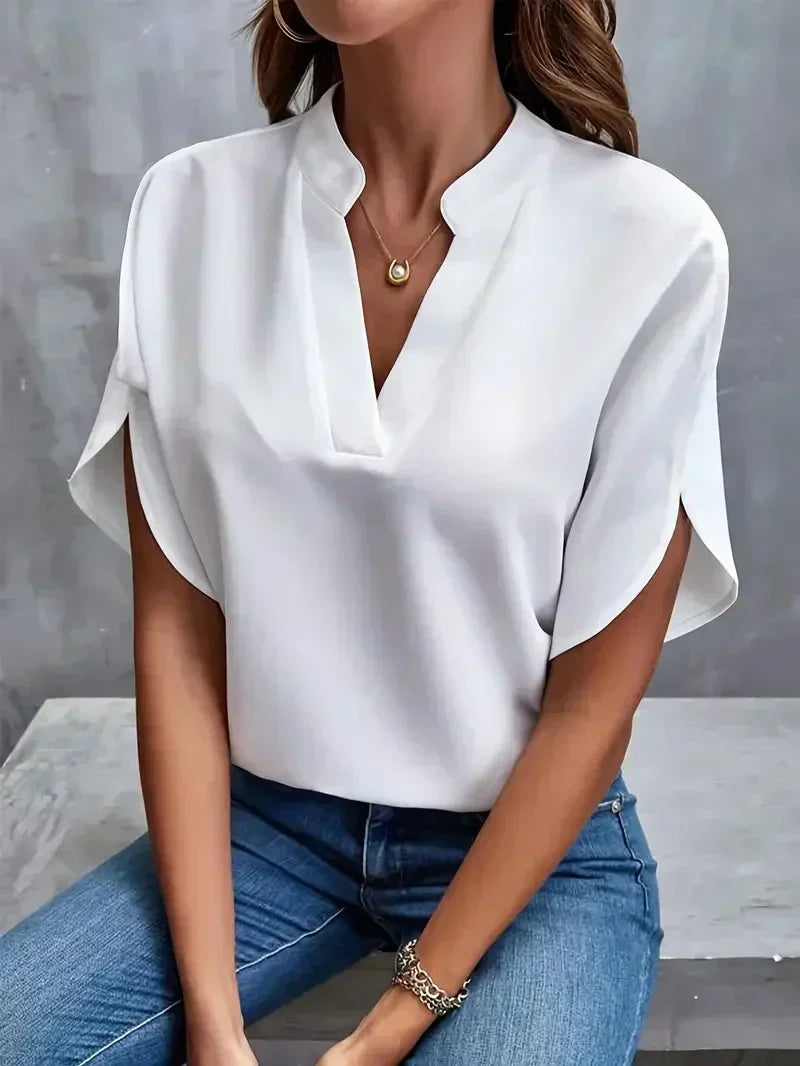 Weiße Bluse Damen, V-Ausschnitt, kurze Ärmel, lässig-elegant, kombiniert mit blauer Jeans, modisches Outfit, ideal für Büro oder Freizeit.