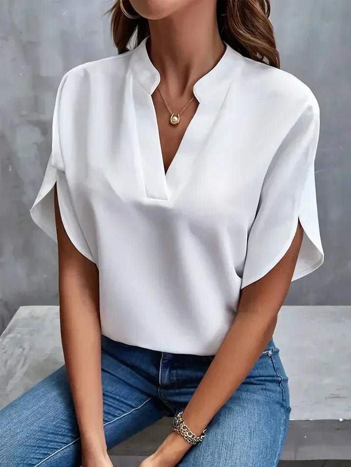 Weiße Bluse Damen, V-Ausschnitt, kurze Ärmel, lässig-elegant, kombiniert mit blauer Jeans, modisches Outfit, ideal für Büro oder Freizeit.