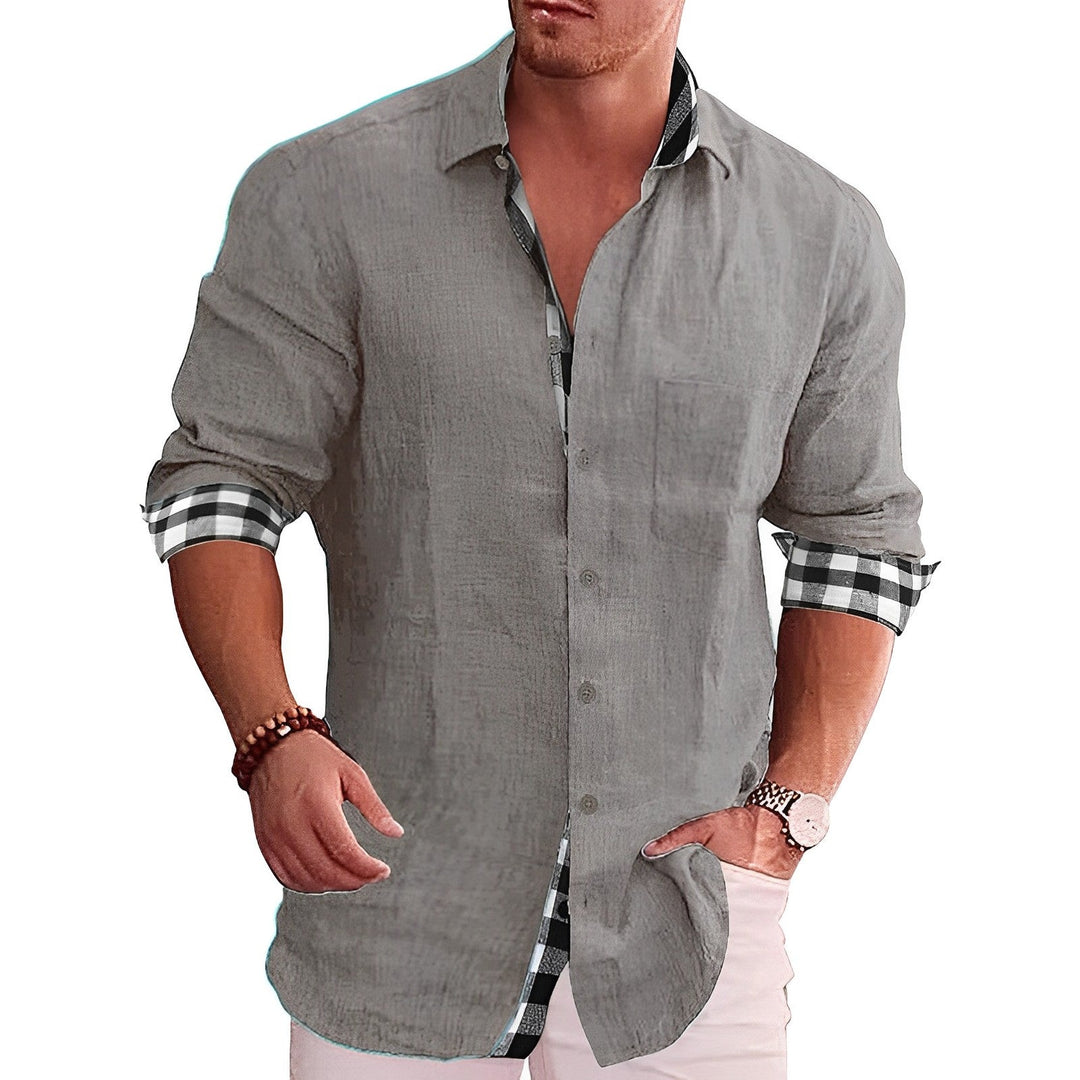 Graues Herrenhemd mit karierten Manschetten, lässig und modern, ideal für Freizeitmode. Perfekt kombiniert mit weißer Hose und Armbanduhr.