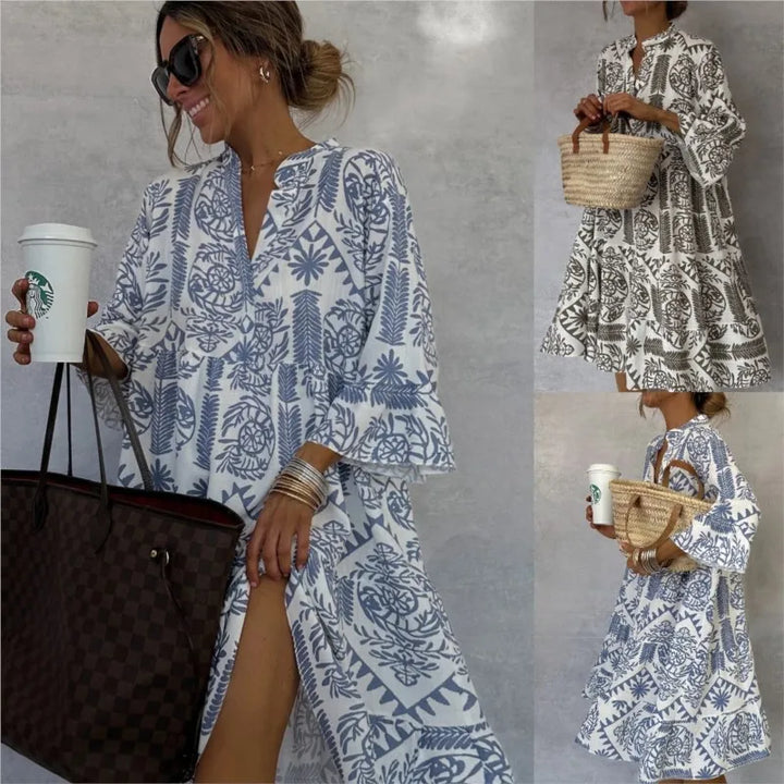 Frau in blau-weißem Sommerkleid mit floralem Muster, hält Starbucks-Becher und Designer-Handtasche. Perfektes Outfit für Strand und Freizeit.