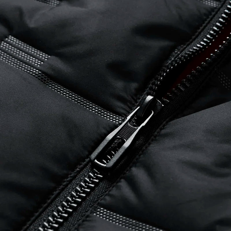 Nahaufnahme eines schwarzen Reißverschlusses auf einer Daunenjacke. Hochwertige Outdoor-Bekleidung, wetterfest, modisch, funktional.