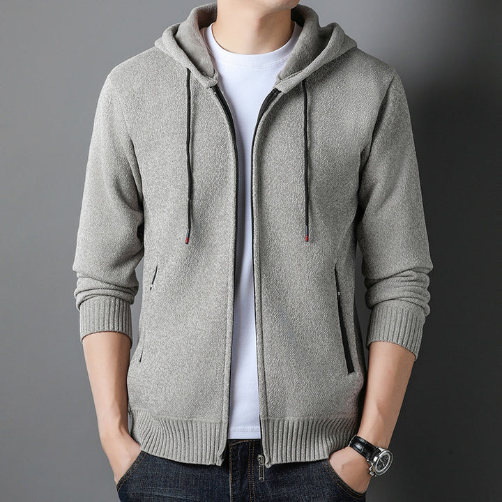 Grauer Herren-Hoodie mit Reißverschluss, Kapuze und Kordelzug, getragen über weißem T-Shirt. Modischer Freizeitlook, ideal für Herbst und Winter.