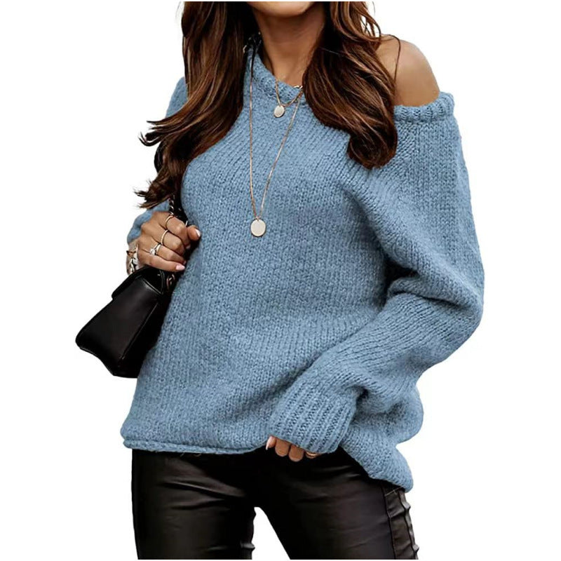Frau in blauem Strickpullover mit schulterfreiem Design, trägt schwarze Lederhose und schwarze Handtasche, modischer Herbst-Look.
