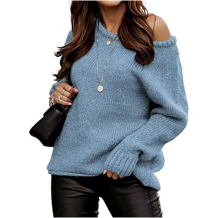 Frau in blauem Strickpullover mit schulterfreiem Design, trägt schwarze Lederhose und schwarze Handtasche, modischer Herbst-Look.