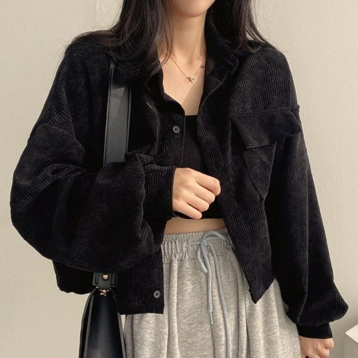 Frau in schwarzer Cordjacke und grauer Jogginghose, modischer Streetwear-Look, lässiger Stil, Herbstmode, trendige Damenbekleidung.