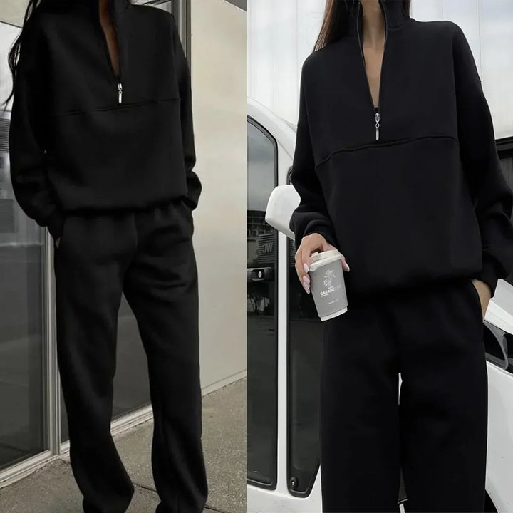 Frau in schwarzem Trainingsanzug mit Reißverschluss, hält Kaffeebecher, steht vor weißem Auto. Modetrend, Freizeitkleidung, urbaner Stil.