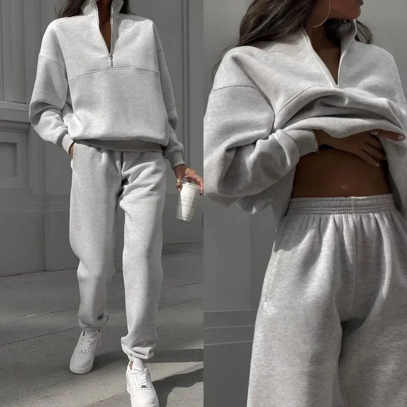 Graues Damen-Sweatshirt und Jogginghose Set, sportlich und bequem, ideal für Freizeit und Fitness. Perfekt kombiniert mit weißen Sneakers.