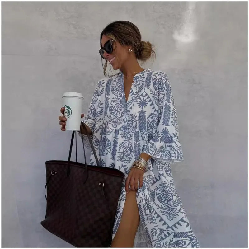 Frau in weißem, gemustertem Kleid mit Sonnenbrille hält Starbucks-Becher und braune Designer-Handtasche. Sommermode, lässiger Stil.