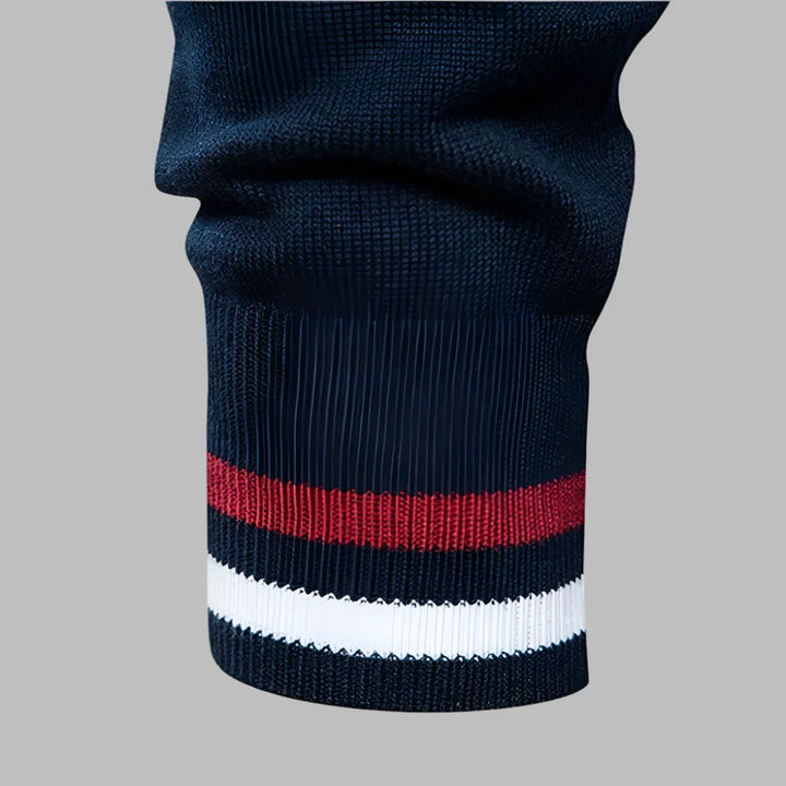 Dunkelblauer Strickärmel mit roten und weißen Streifen, modisches Design, hochwertige Textur, Detailansicht, stilvolle Bekleidung.