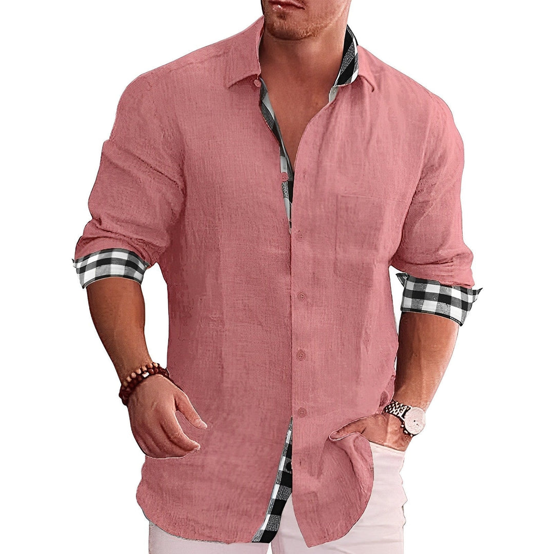 Mann in rosa Leinenhemd mit karierten Manschetten, lässiger Stil, Hände in Hosentaschen, modisches Herrenoutfit, Sommermode.