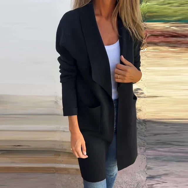 Frau in schwarzem Cardigan und weißem Top, lässiger Herbstlook, modische Damenbekleidung, Outdoor-Hintergrund, stilvolle Freizeitmode.