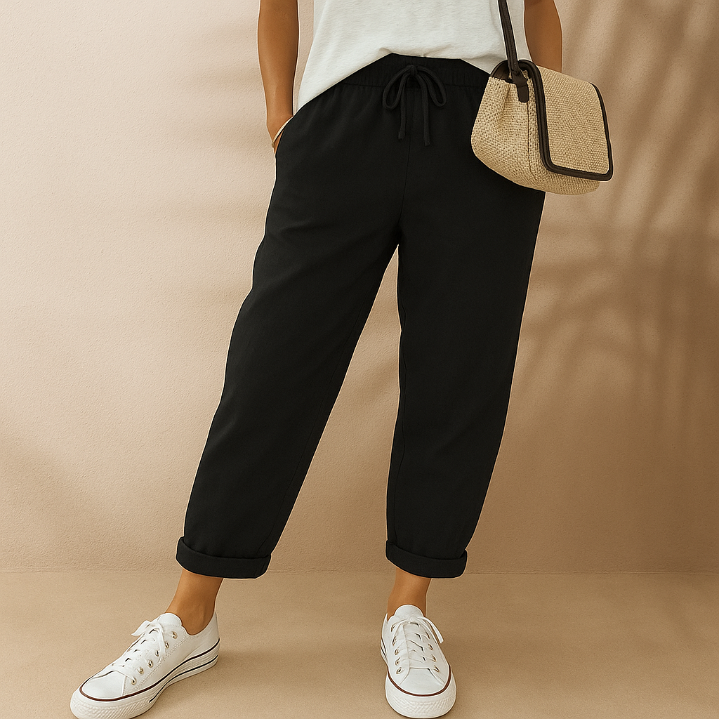 Frau in schwarzer Hose und weißen Sneakers, hält eine beige Handtasche. Modetrend, lässiger Stil, Damenbekleidung, bequeme Freizeitmode.