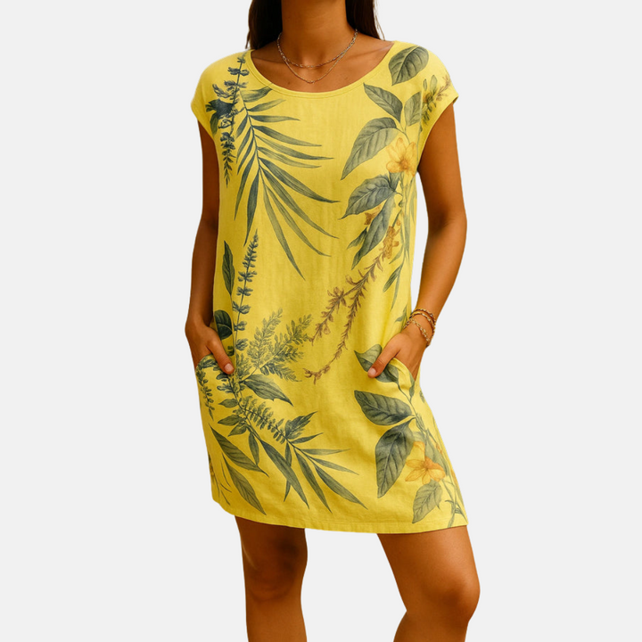 Gelbes Sommerkleid mit tropischem Blattmuster, kurzen Ärmeln und Taschen. Perfekt für Strandmode und lässige Sommeroutfits.