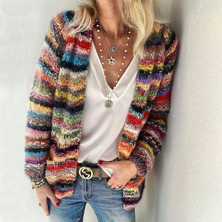 Person, die einen bunten gestreiften Cardigan über einem weißen Hemd mit neutralem Hintergrund trägt