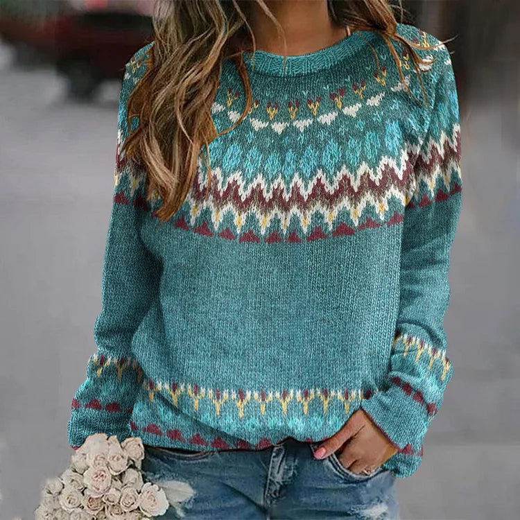 Frau in blauem Norwegerpullover mit buntem Muster, hält Blumenstrauß. Modetrend Herbst/Winter, lässiger Stil, gemütlicher Strickpullover.