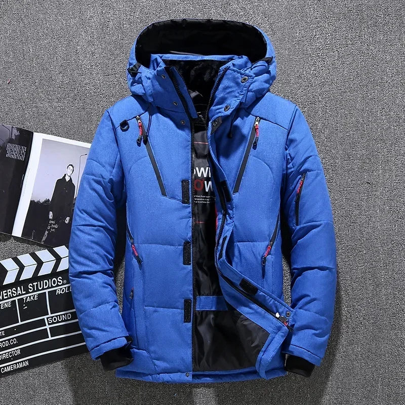 Blaue Winterjacke mit Kapuze, Reißverschlüssen und Taschen, ideal für Outdoor-Aktivitäten. Herrenmode, warme Daunenjacke, stilvoll und funktional.