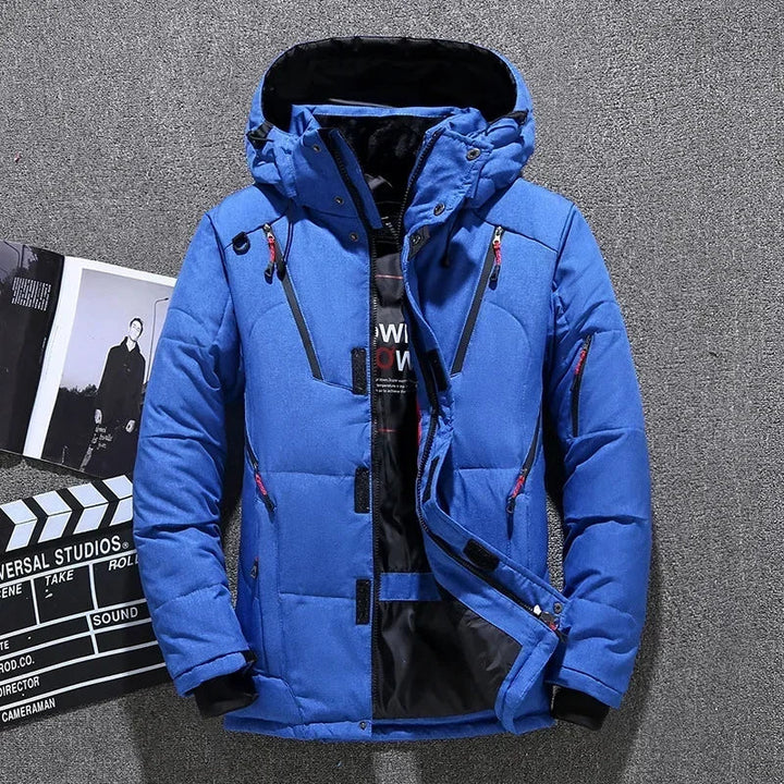 Blaue Winterjacke mit Kapuze, Reißverschlüssen und Taschen, ideal für Outdoor-Aktivitäten. Herrenmode, warme Daunenjacke, stilvoll und funktional.