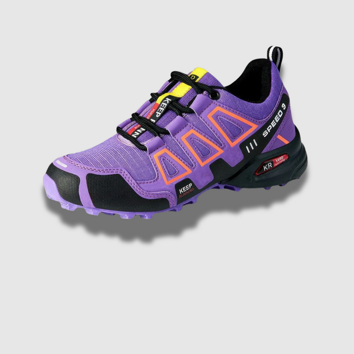 Lila Trailrunning-Schuh mit orangefarbenen Akzenten, robustem Profil und Schnellschnürsystem, ideal für Outdoor-Aktivitäten und Sport.