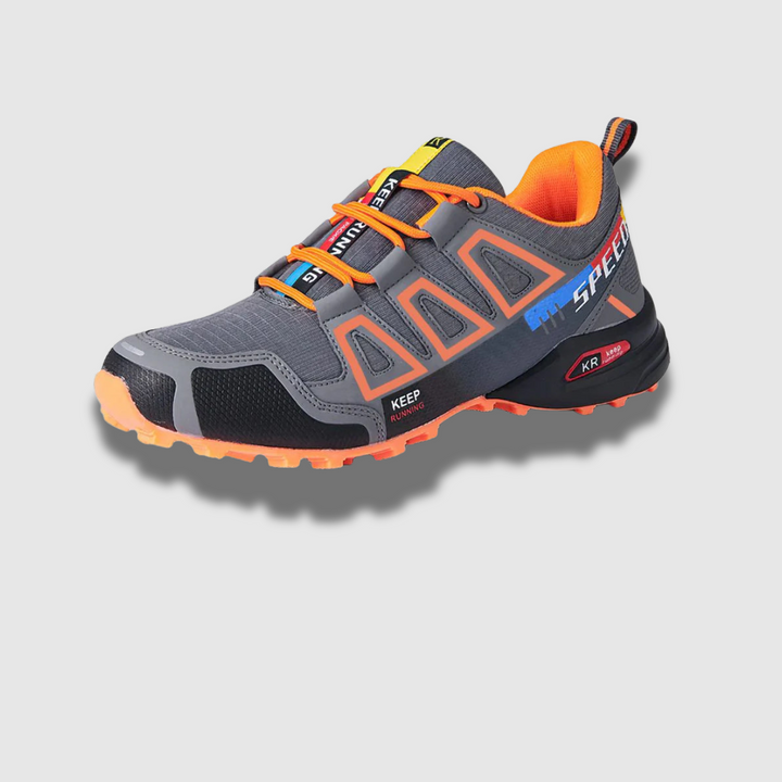 Grauer und orangefarbener Trailrunning-Schuh mit robustem Profil, atmungsaktivem Mesh und verstärkter Zehenkappe. Ideal für Outdoor-Abenteuer.