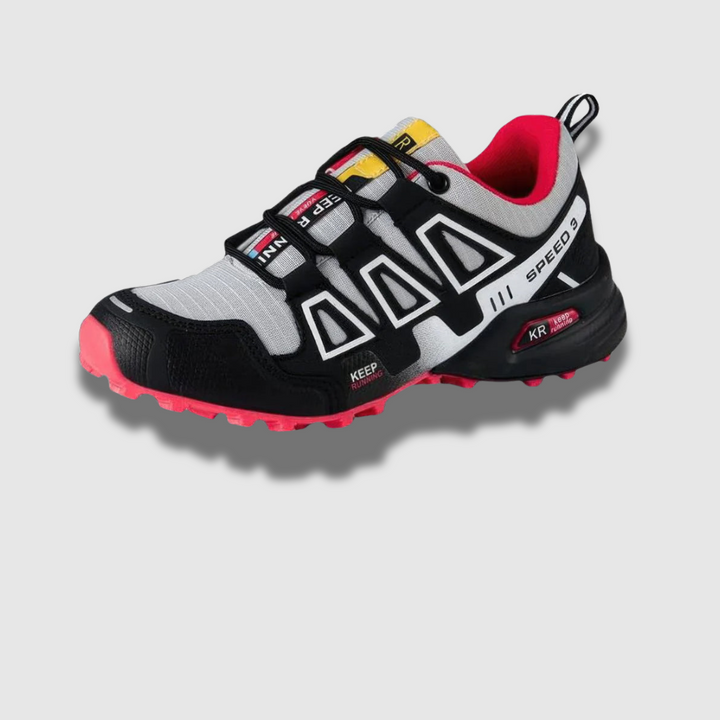 Schwarz-weißer Trailrunning-Schuh mit roter Sohle und Schnürsystem, ideal für Outdoor-Sportarten. Leicht, atmungsaktiv, rutschfest.