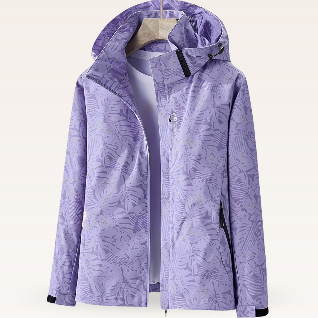 Lila Damen-Windjacke mit Kapuze, floralem Muster und Reißverschluss, auf einem Kleiderbügel. Perfekt für Outdoor-Aktivitäten und modische Freizeitkleidung.