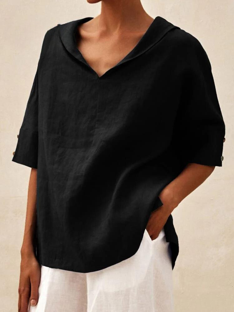 Schwarze Leinenbluse mit V-Ausschnitt und halblangen Ärmeln, kombiniert mit weißer Hose. Elegante Damenmode, lässiger Stil, hochwertige Stoffe.
