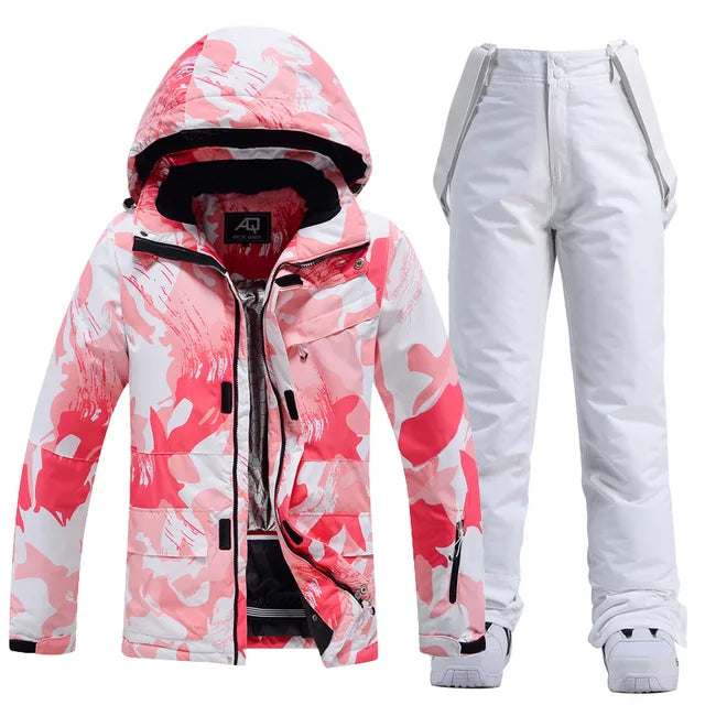 Rosa-weiße Skijacke mit Kapuze und weiße Skihose für Damen. Winterbekleidung, wasserdicht, atmungsaktiv, ideal für Skifahren und Snowboarden.