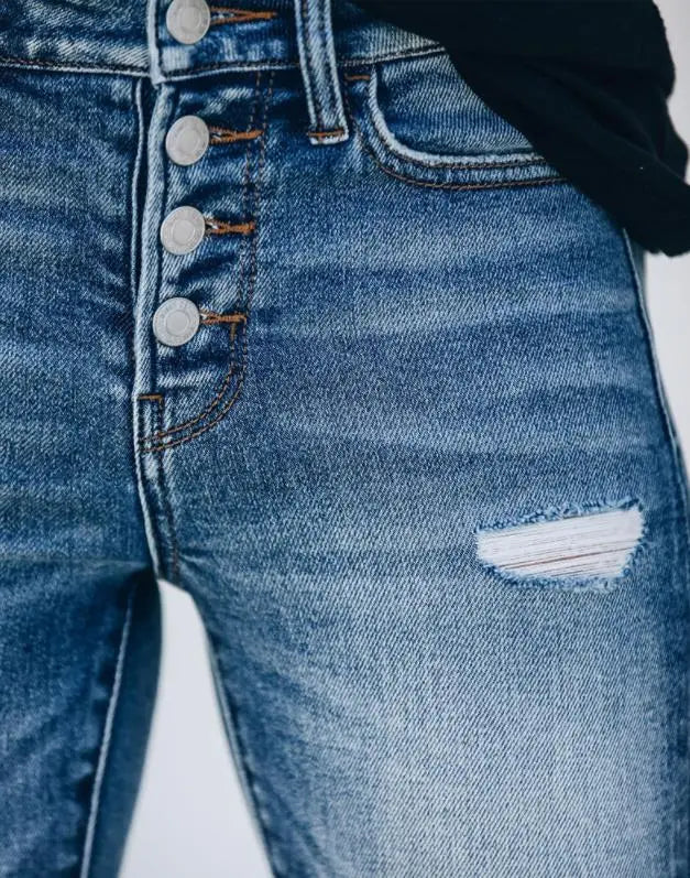 Damenjeans mit Knopfleiste und Riss, blaue Denim-Textur, modische Freizeitkleidung, Nahaufnahme, trendige Jeansmode.