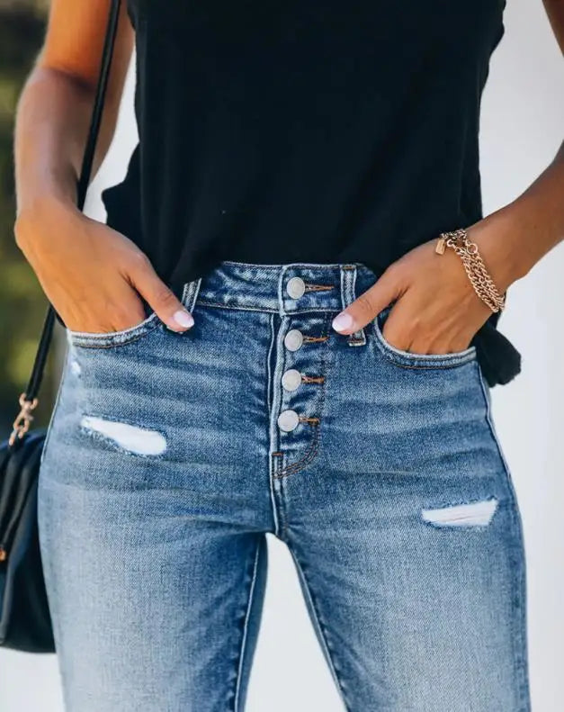 Frau in zerrissener Jeans und schwarzem Top, Hände in den Taschen, modischer Look, Freizeitkleidung, trendige Damenmode, Nahaufnahme.