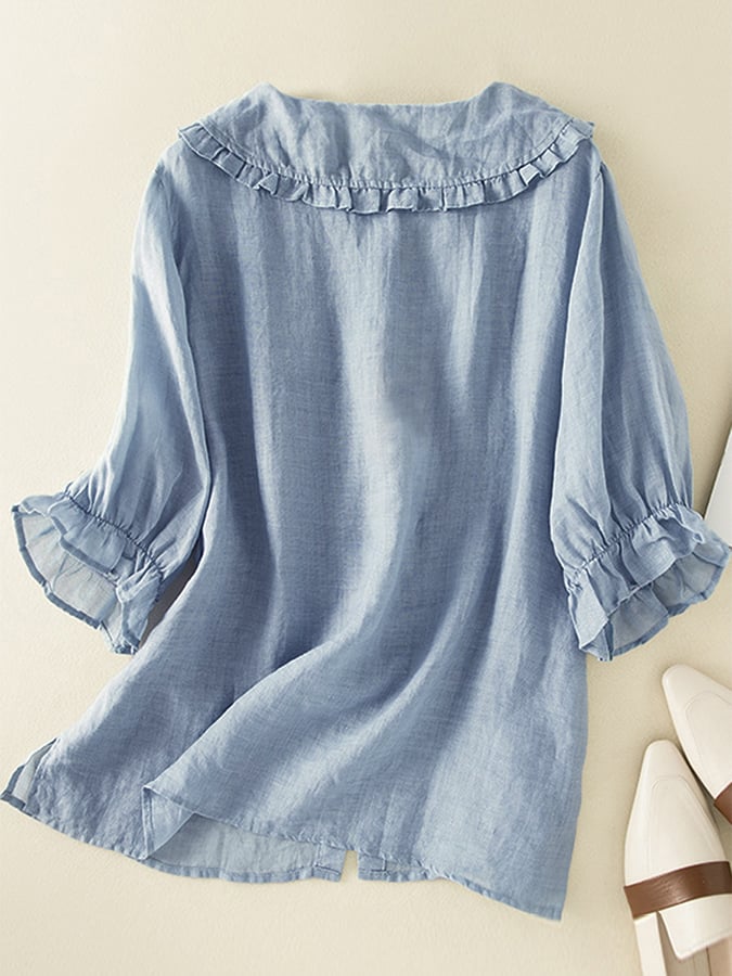 Hellblaue Damenbluse aus Leinen mit Rüschenkragen und 3/4-Ärmeln, lässiger Stil. Perfekt für Sommermode und Freizeitoutfits.