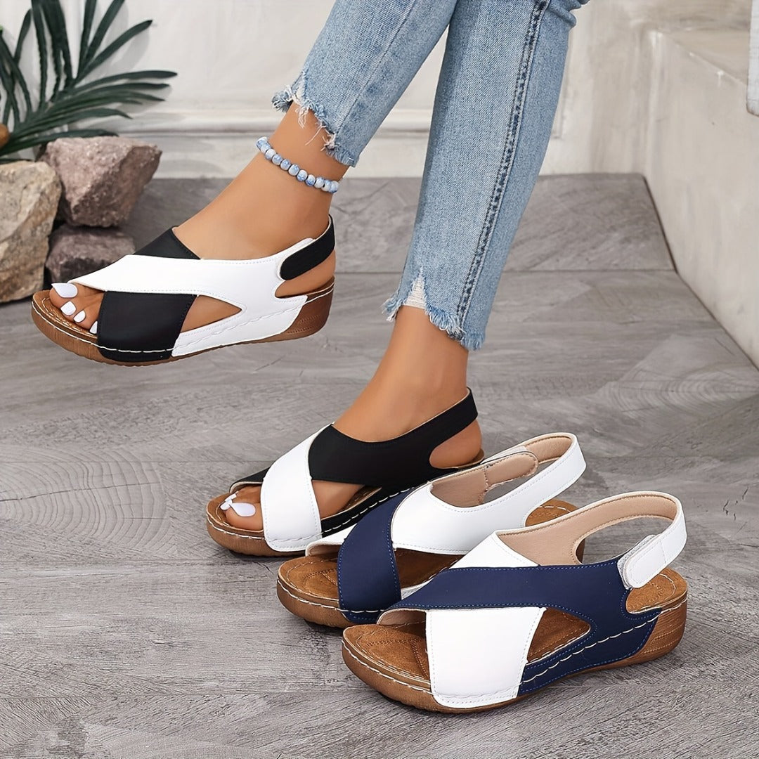 Damen Sandalen mit Keilabsatz, in Schwarz-Weiß und Blau-Weiß, auf grauem Boden. Modische Sommerschuhe, bequem und stilvoll.