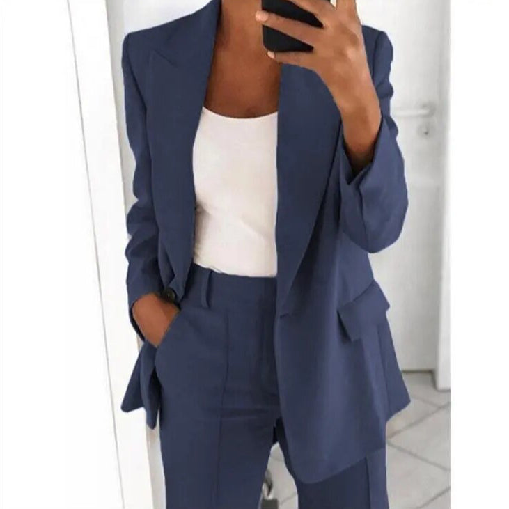 Dame in blauem Anzug mit weißem Top, hält Smartphone. Businessmode, eleganter Look, moderne Damenbekleidung, Büro-Outfit, stilvoller Blazer.