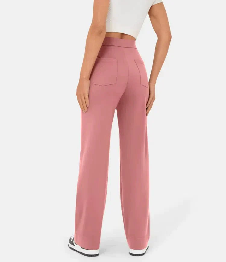 Frau in rosa, weit geschnittener Hose und weißem Crop-Top, Rückansicht. Modetrend, Damenbekleidung, lässiger Stil, bequeme Passform.
