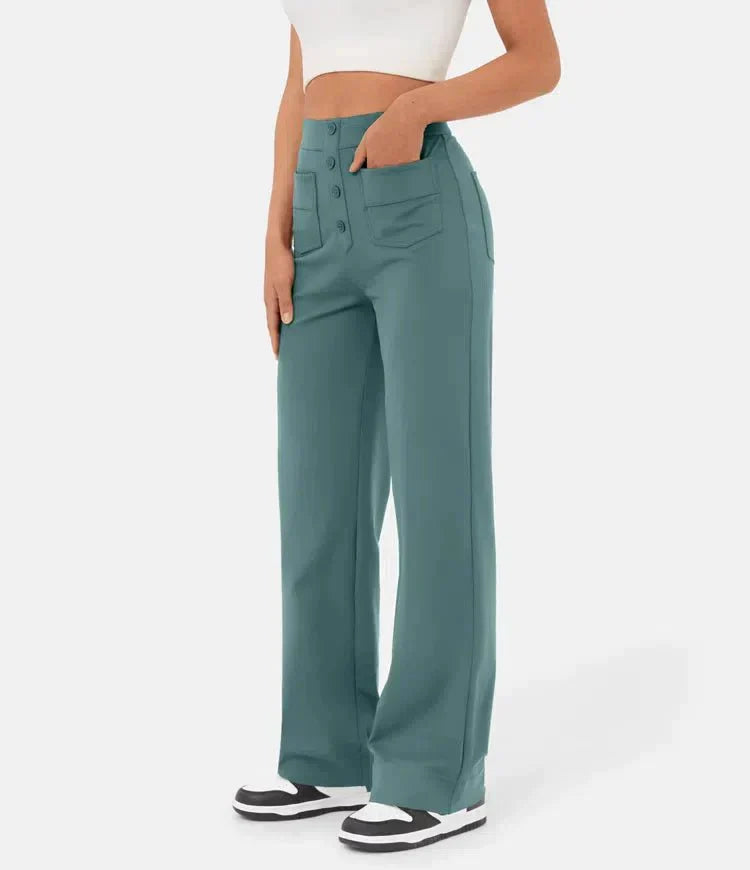 Frau trägt weite, grüne Hose mit Taschen und Knöpfen, kombiniert mit weißem Crop-Top und Sneakers. Modetrend, Damenbekleidung, lässiger Stil.